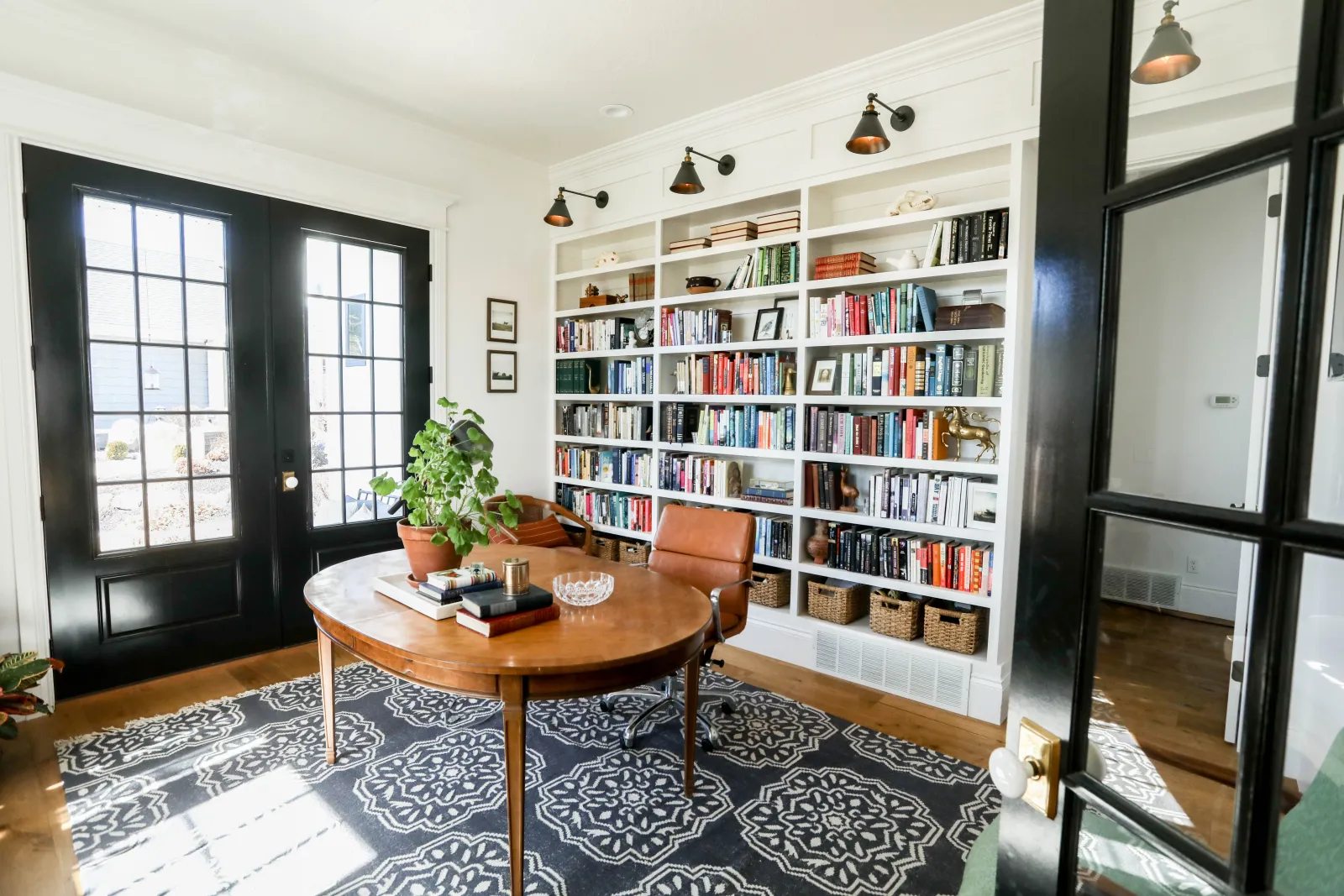 home with a table in a library with a rug on wood floor