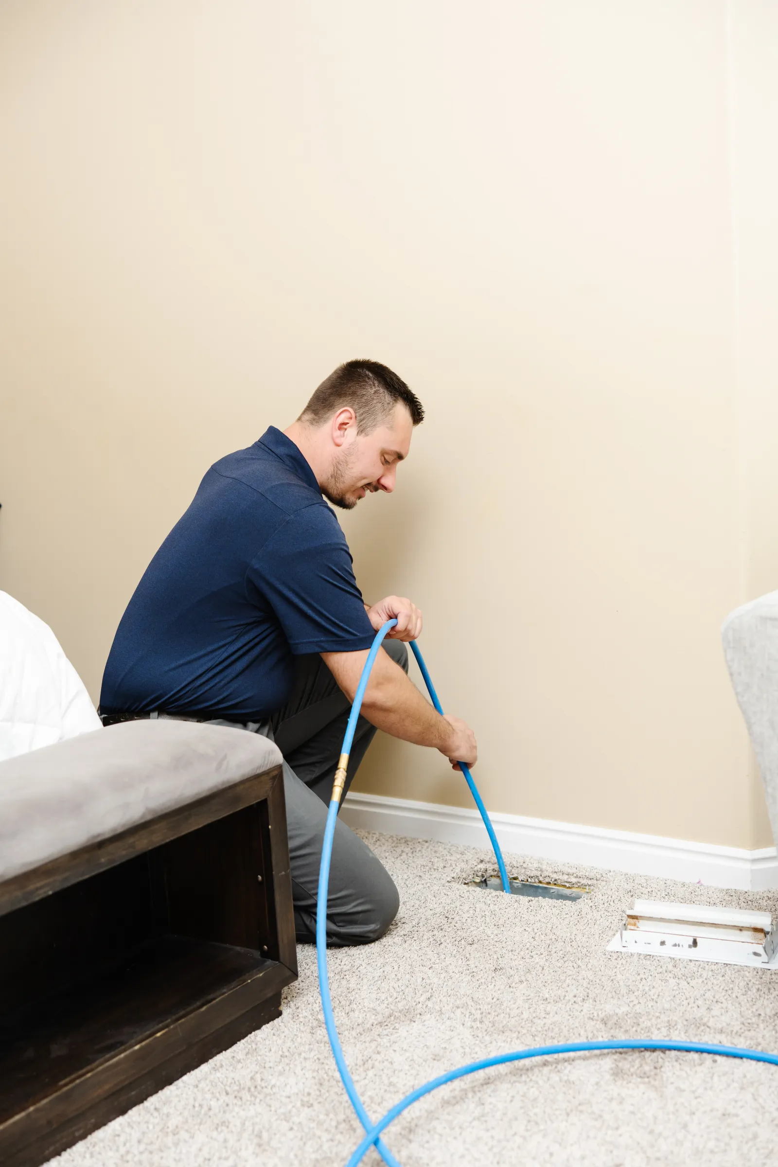 man cleaning air duct in a bedroom