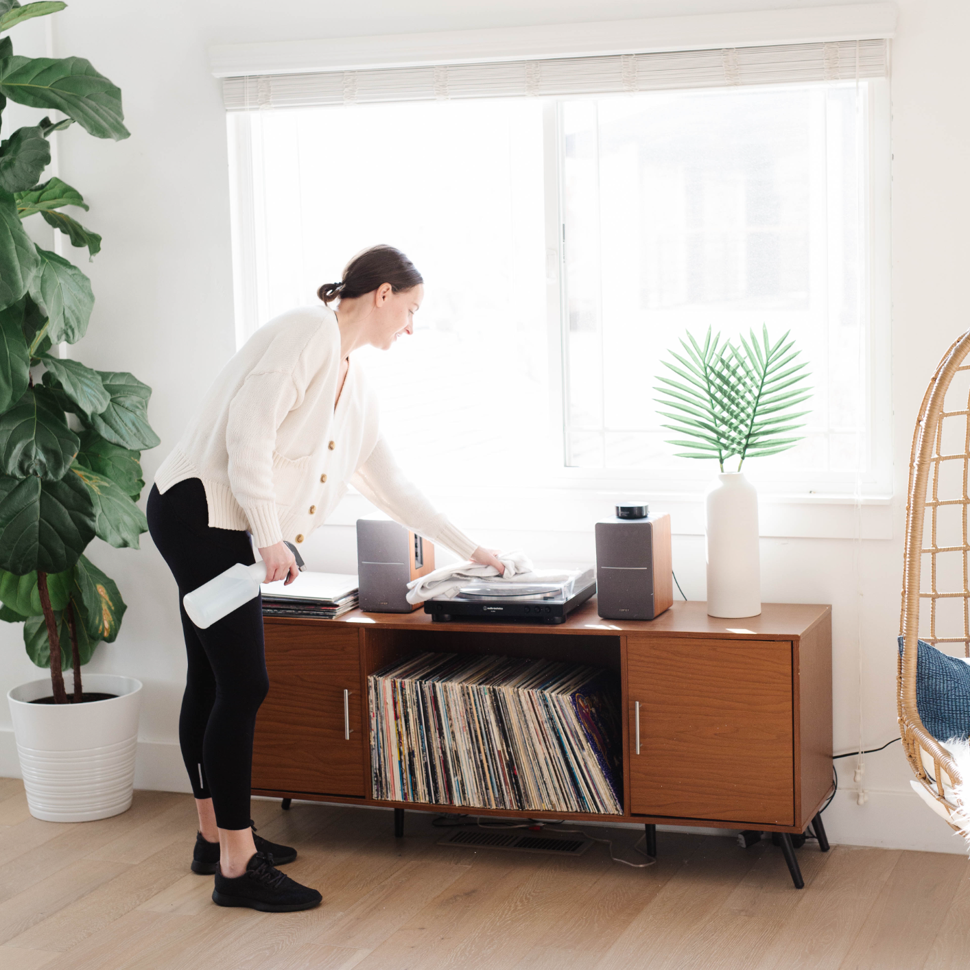 Woman dusting her living room in her home to limit the spread of dust in bathroom